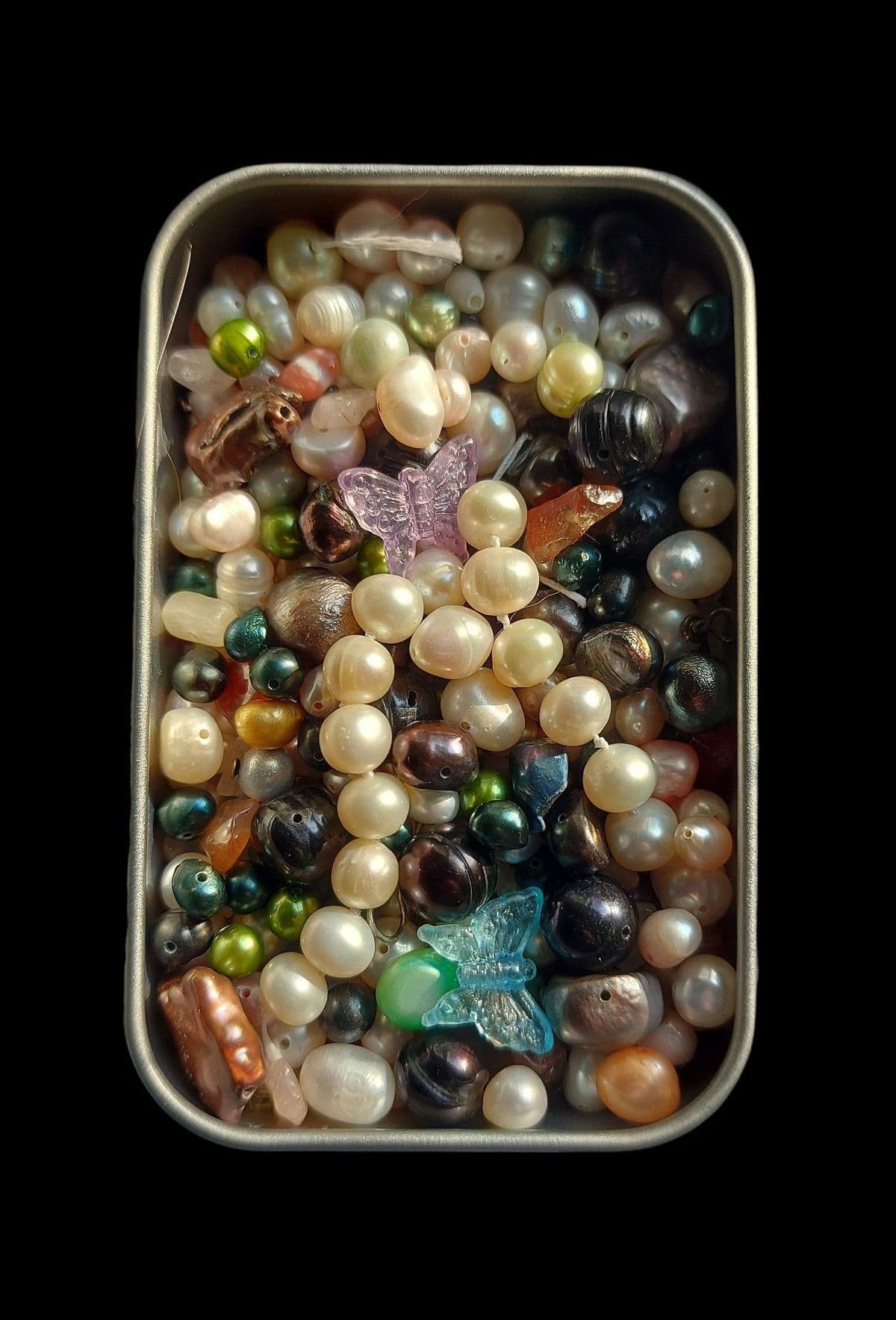 vintage pearl necklaces in a tin can