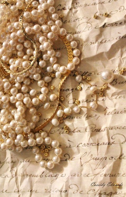 vintage pearl jewelry over old paper